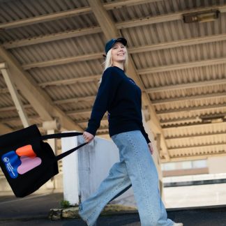 kuvassa nainen kantaa isoa kangaskassia